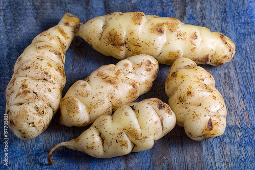 Oxalis tuberosa also known as oca tuber on rustic background photo