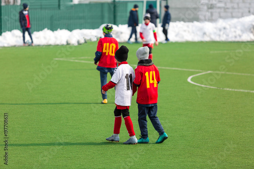 Young kids football tournament - children play match on the winter soccer field