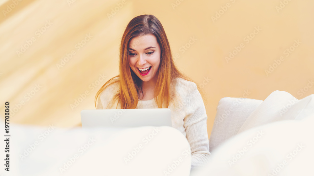 Happy young woman using her laptop computer at home Happy young woman using her laptop computer at home