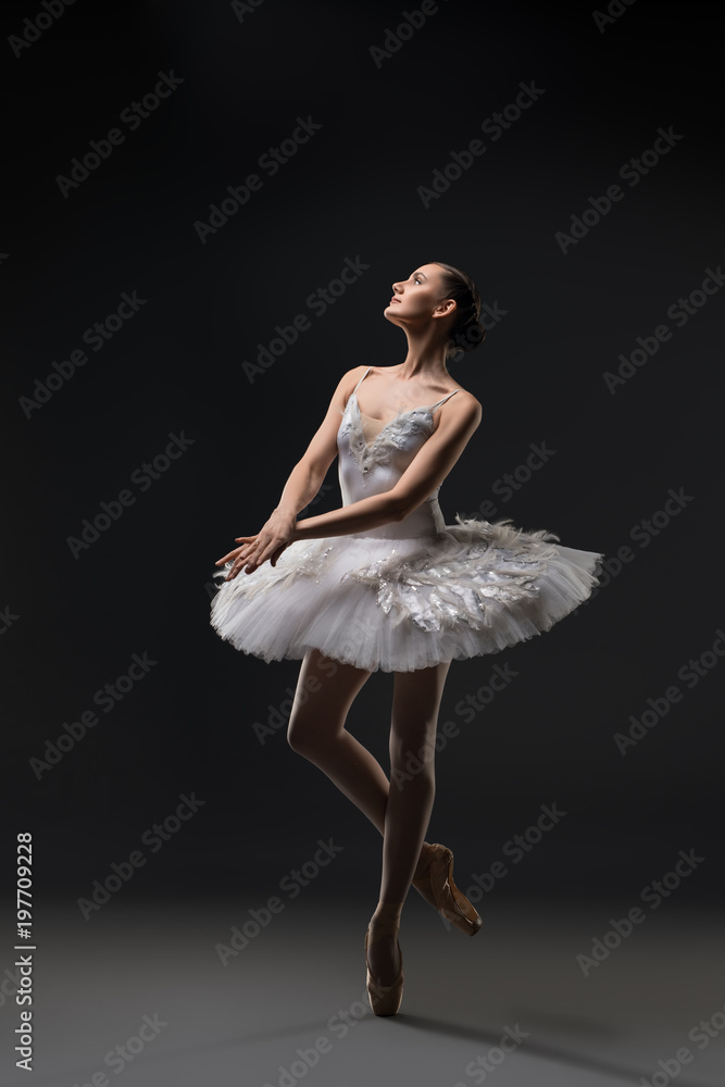 Fototapeta premium Ballerina in white tutu dancing in the dark
