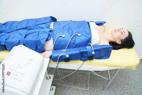 Photos Procedure pressotherapy in clinic. Young sexy girl in costume