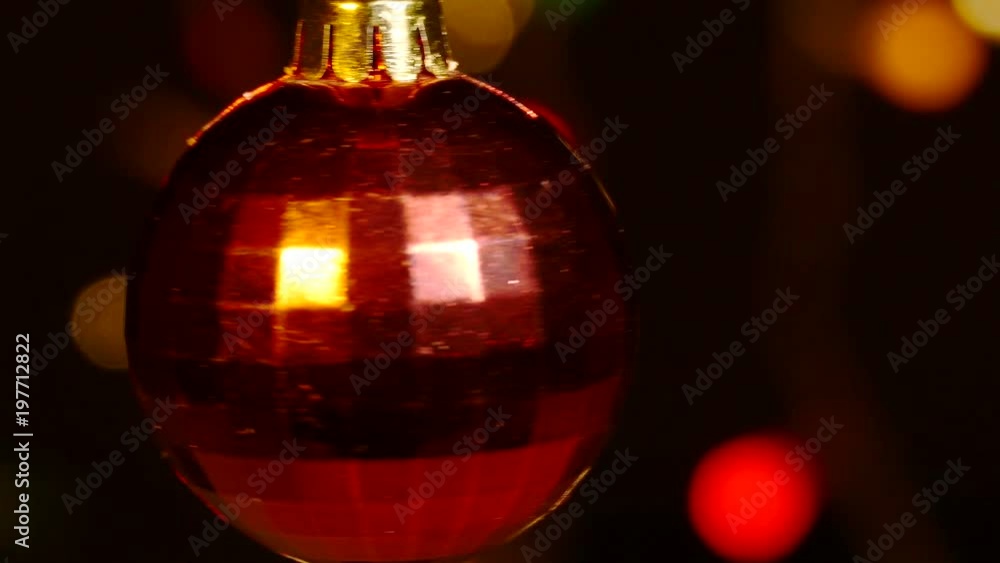 4K. Red toy ball rotate against festive lights. Christmas or New Year symbol 4K. Red toy ball rotate against festive lights. Christmas or New Year symbol