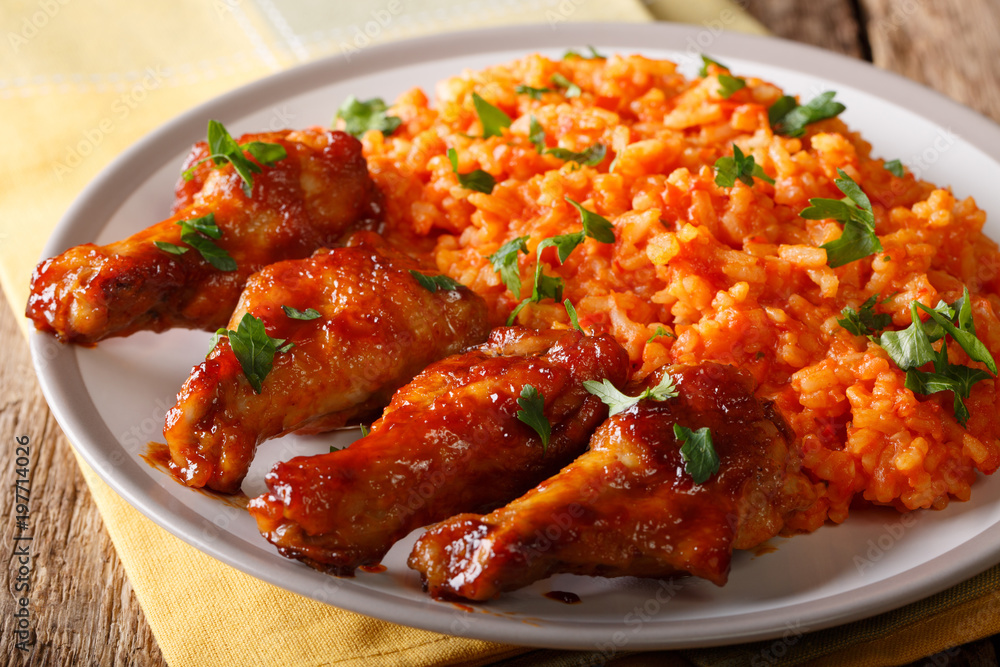 Nigerian food party: Jollof rice with fried chicken wings close-up. horizontal