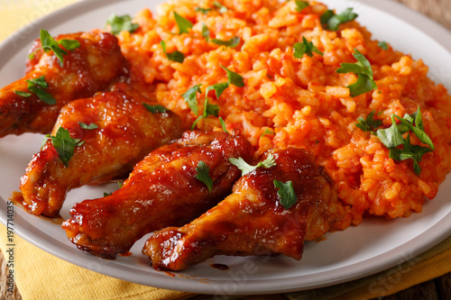 Nigerian food: spicy Jollof rice with fried chicken closeup. horizontal