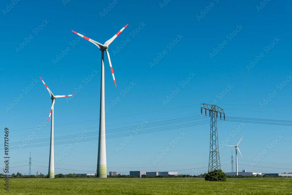 Wind turbines and overhead lines on a sunny day seen in Germany Wind turbines and overhead lines on a sunny day seen in Germany