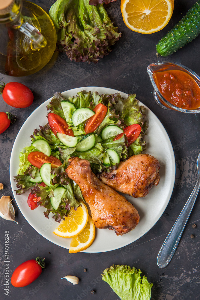Fried chicken legs and fresh salad on a dark background Fried chicken legs and fresh salad on a dark background