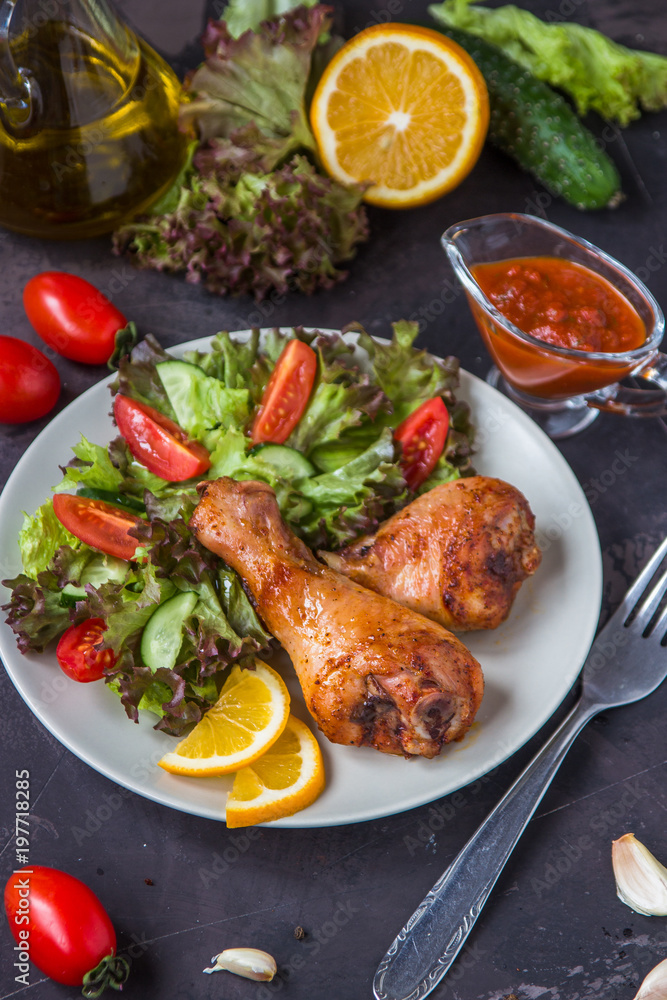 Fried chicken legs and fresh salad on a dark background Fried chicken legs and fresh salad on a dark background