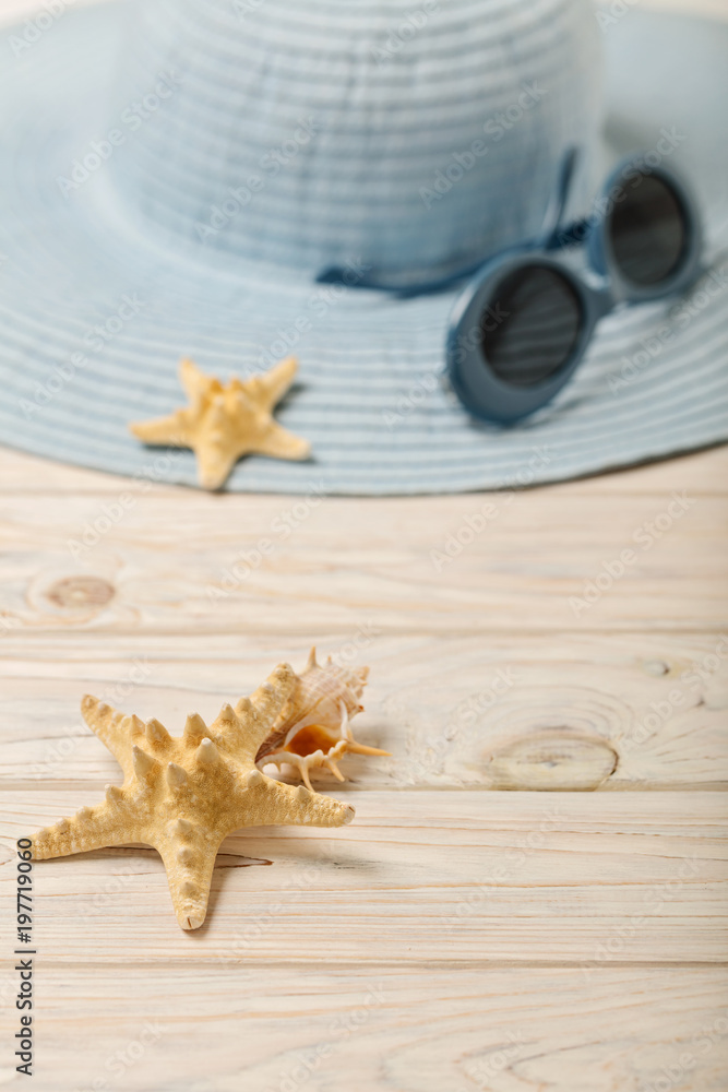 Beach summer concept. Blue female hat and sunglasses on a light wooden background. Beach summer concept. Blue female hat and sunglasses on a light wooden background.