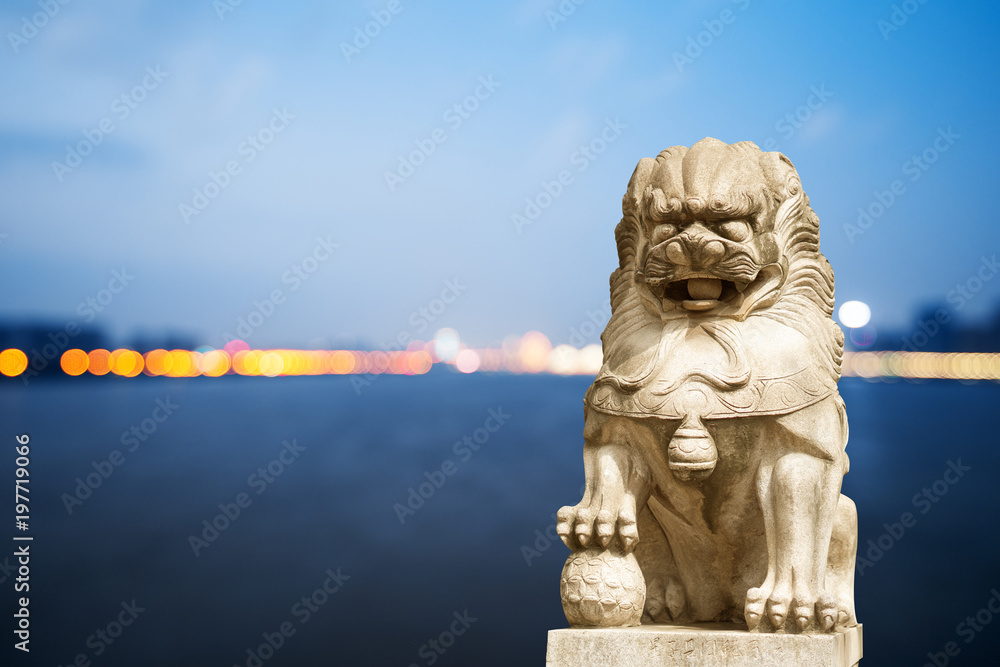 white stone lion sculpture in blue sunny sky