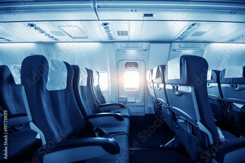 Comfortable seats in cabin of huge aircraft with screens in chairs back photo