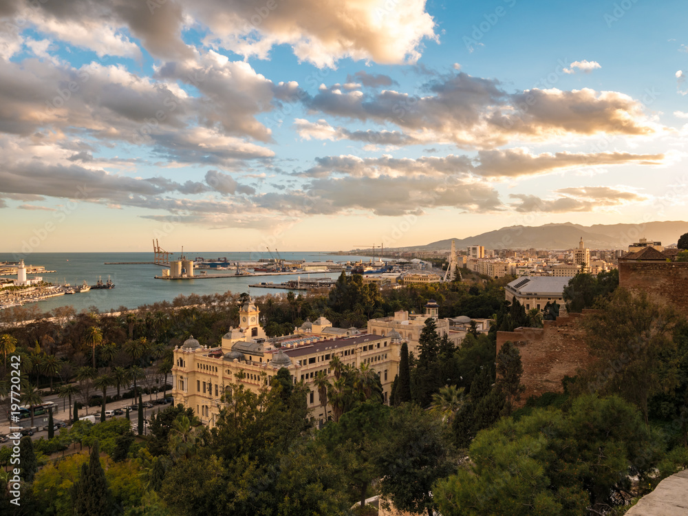 Panorama view of the port of Malaga, Spain and the city hall building at sunset with an epic cloudy sky