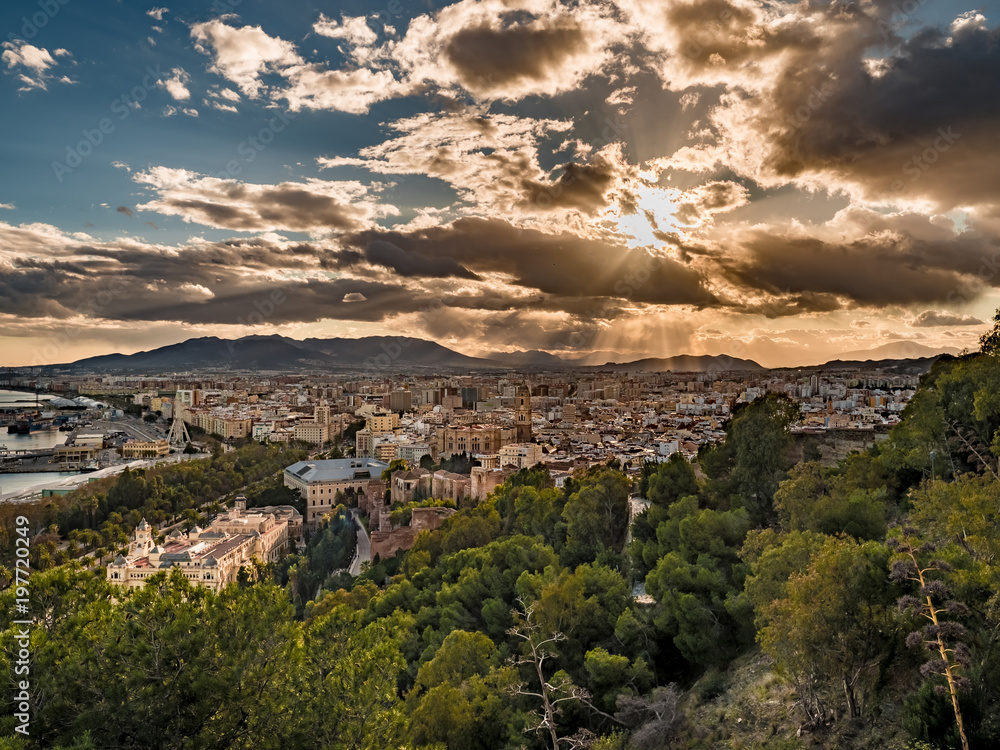 Panorama view of the port of Malaga, Spain and the city hall building at sunset with an epic cloudy sky