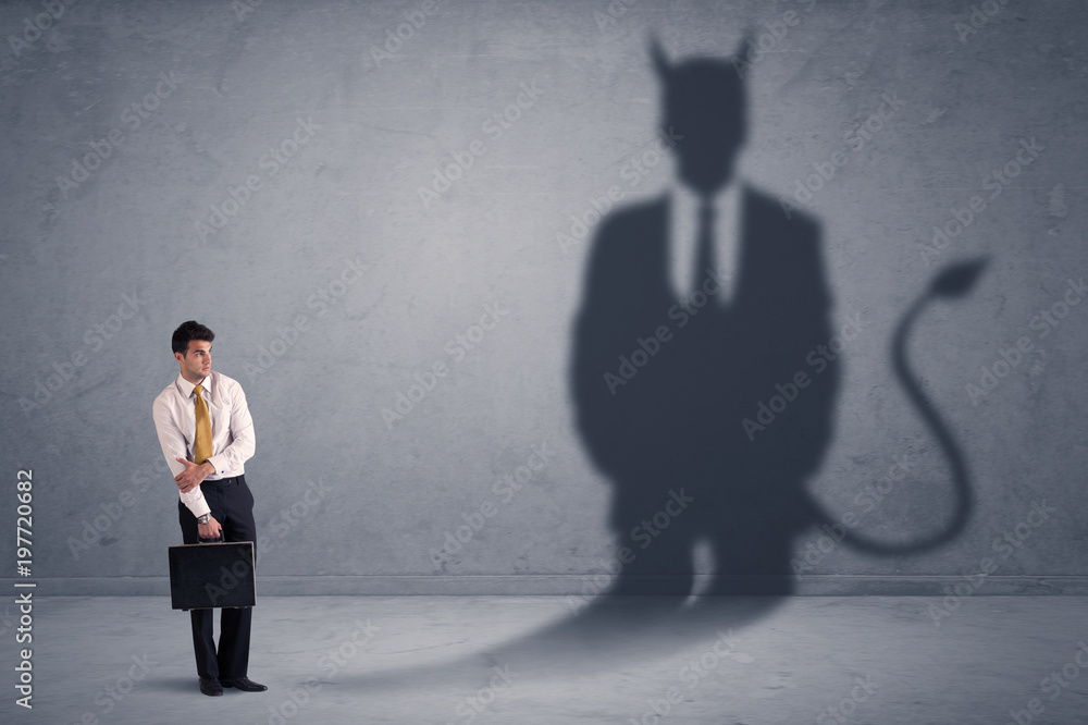 Obraz premium Business man looking at his own devil demon shadow concept