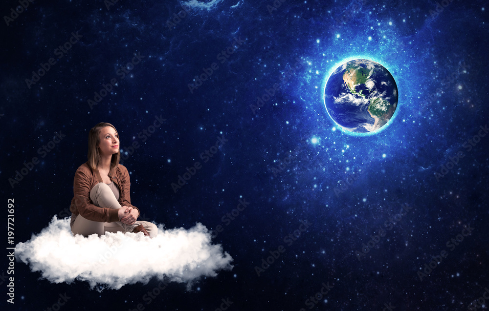Woman sitting on cloud looking at planet earth Woman sitting on cloud looking at planet earth