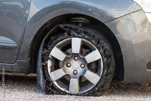 Vászonkép Destroyed blown out tire with exploded, shredded and damaged rubber on a modern suv automobile