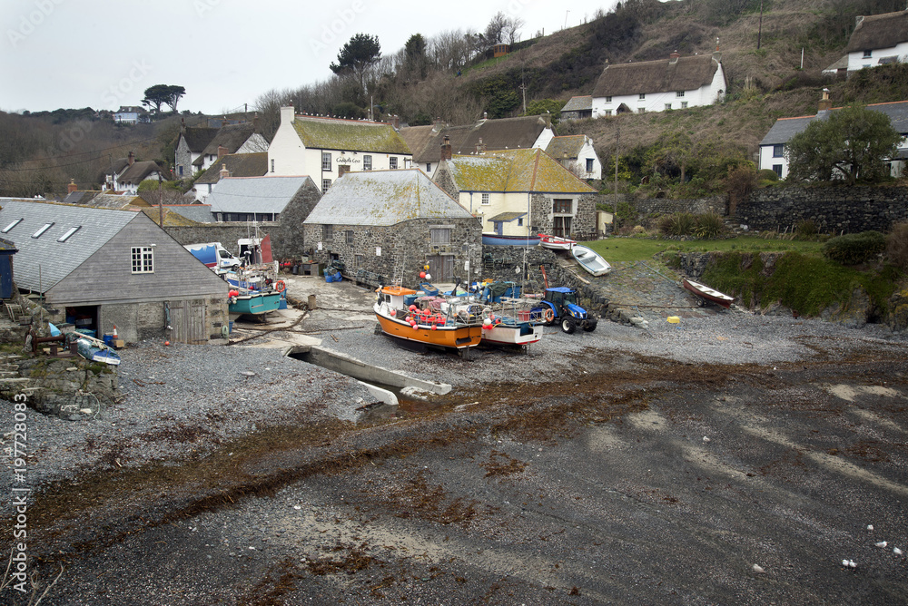 Traditional vintage Cornish fishing village landscape with boats on shore awaiting next morning