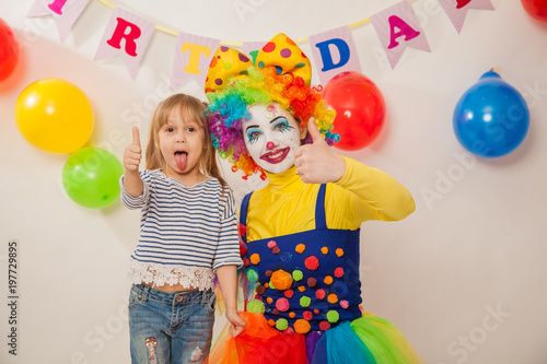 clown girl on the birthday of a child. A party for a child. Emotional Child fools around