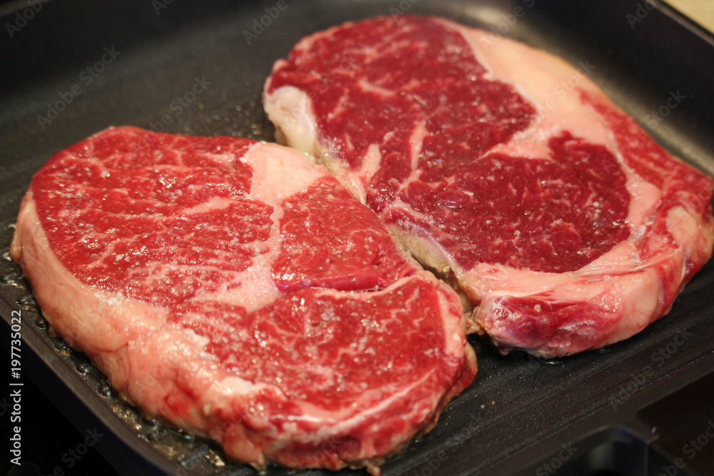 Raw steaks cooked on the pan