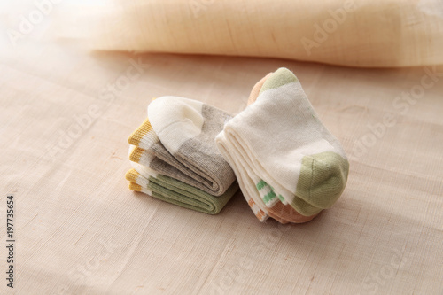 Baby socks hanging on the clothesline on wooden background