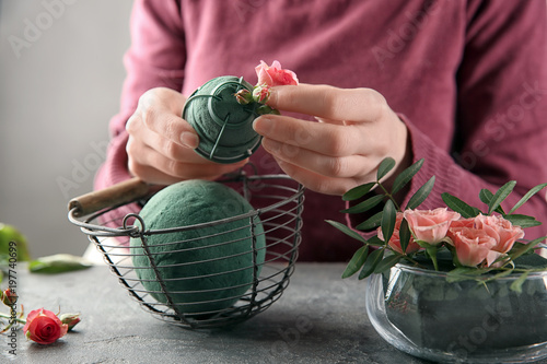 Female florist using sponge for work at table