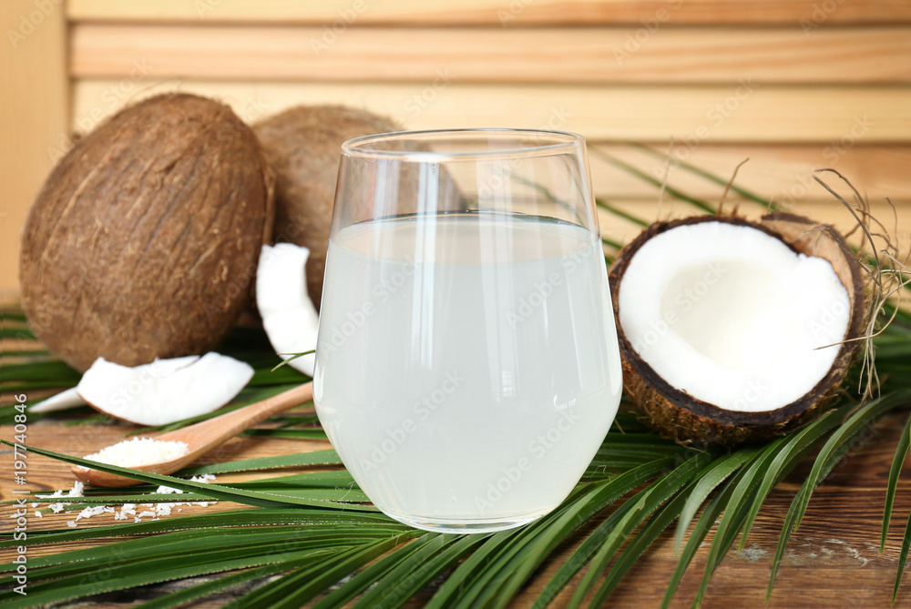 Glass of coconut water on wooden table Glass of coconut water on wooden table