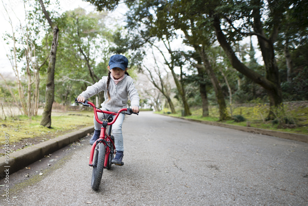 赤い自転車に乗る女の子