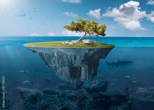 Idyllic small island with lone tree deep in the ocean