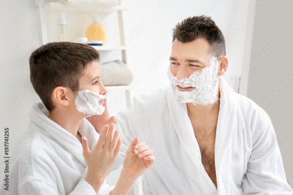 Dad teaching his son to shave in bathroom