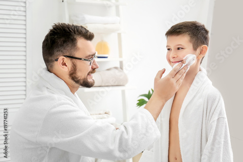 Dad teaching his son to shave in bathroom