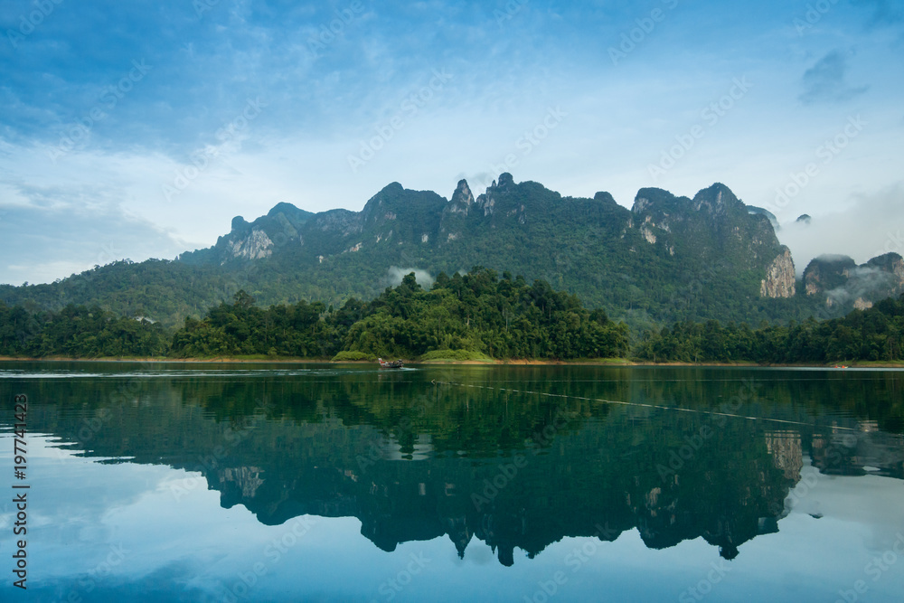 View of lake landscape with rainy mountain forest and cloudy in the background.