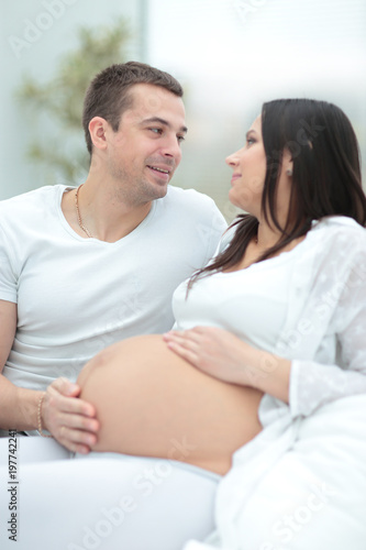 Pregnant woman with her husband relaxing at home