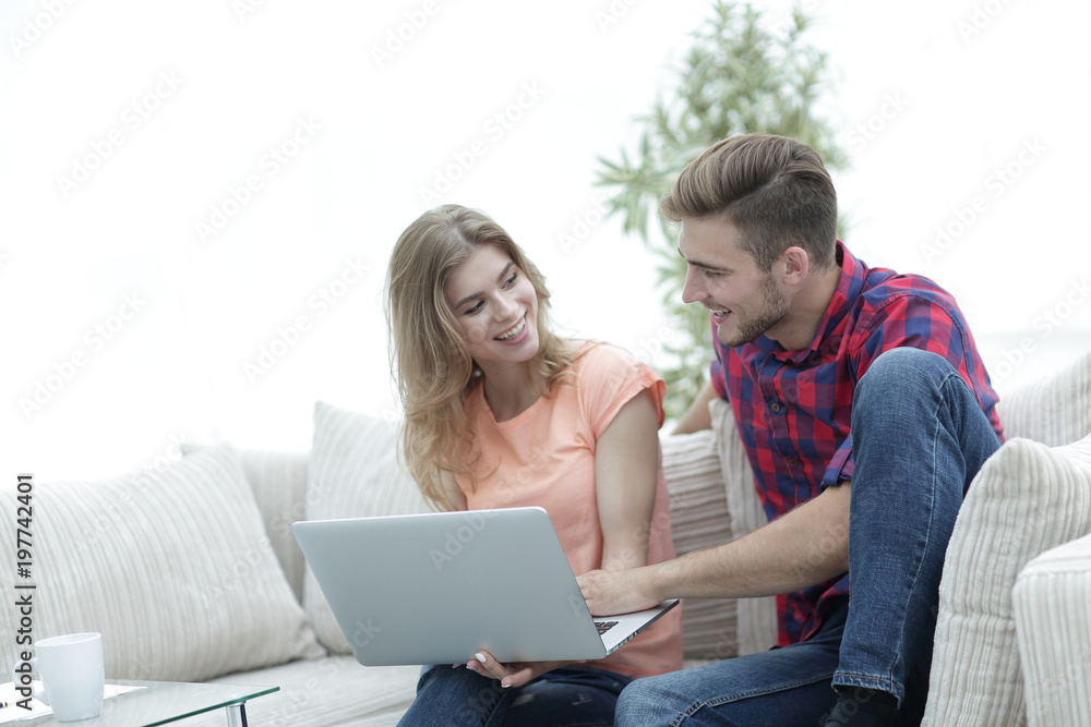 young man and his girlfriend looking at pictures on the laptop. young man and his girlfriend looking at pictures on the laptop.
