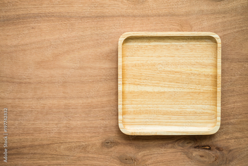Top view of unused brand new brown handmade wooden dish plate on wooden table background Top view of unused brand new brown handmade wooden dish plate on wooden table background