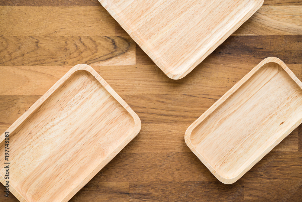 Top view of unused brand new brown handmade wooden kitchen utensil, dish plate on wooden table background Top view of unused brand new brown handmade wooden kitchen utensil, dish plate on wooden table background