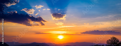 Panoramic landscape of Mountains at sunset with clouds and sun rays