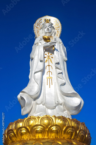 The Statue of Guan Yin outdoors on a beautiful blue background.