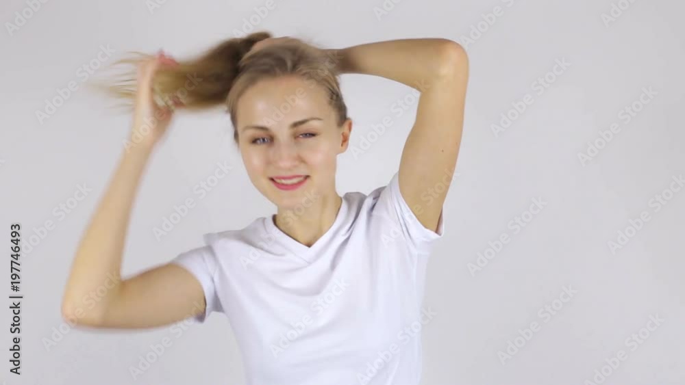Beautiful woman collects her hair in a ponytail Beautiful woman collects her hair in a ponytail