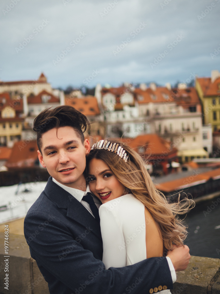 Groom and bride in charles bridge. winter wedding in Prague Groom and bride in charles bridge. winter wedding in Prague
