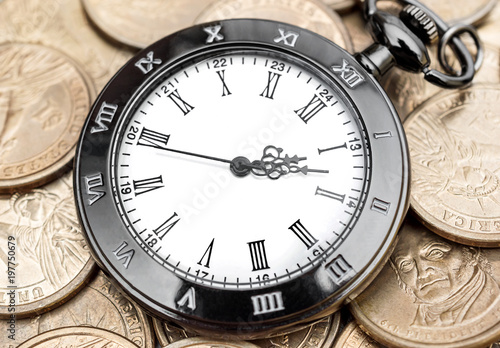 Pocket watch on the golden coins. Business concept.