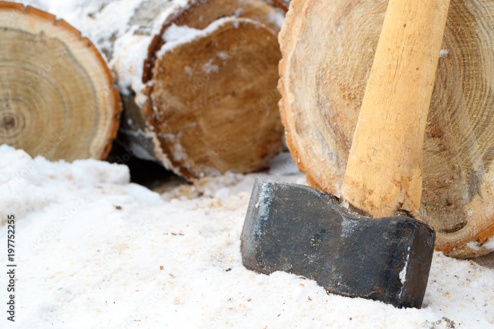 work in the village in winter to chop wood with a cleaver, snow and chocks are wooden work in the village in winter to chop wood with a cleaver, snow and chocks are wooden