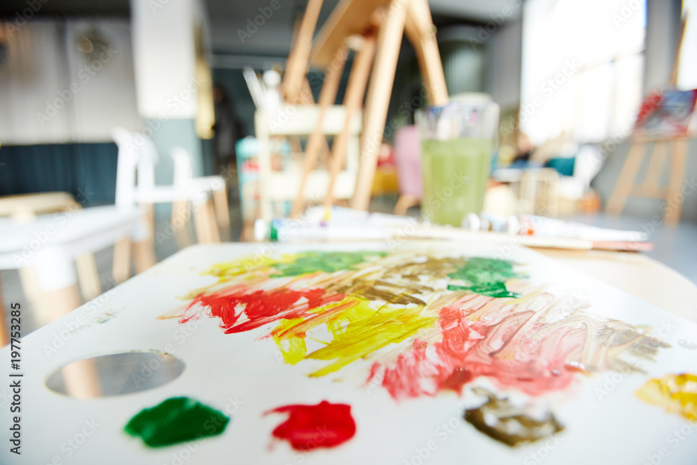 Naklejka premium Palette of an artist with some vibrant colors for mixing in studio of painting