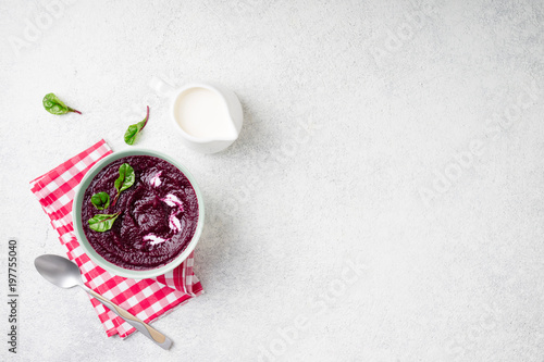 Beetroot cream soup in bowl on white stone background. Detox beetroot puree smoothie with chard leaves. Dieting, clean eating, slimming, vegetarian food concept