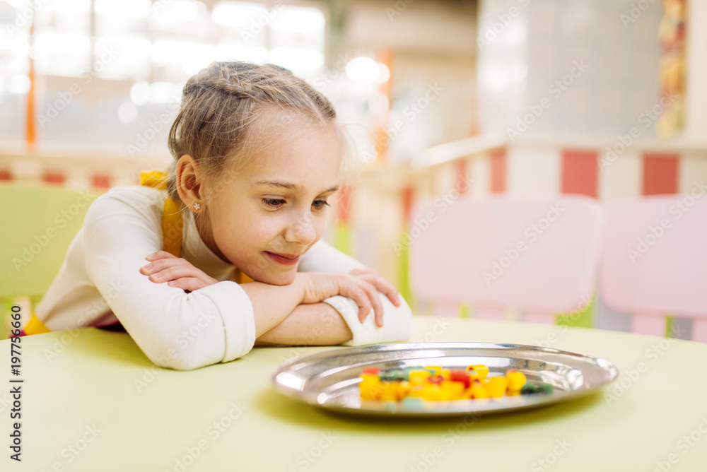 Little girl watching on sugar caramel in plate Little girl watching on sugar caramel in plate