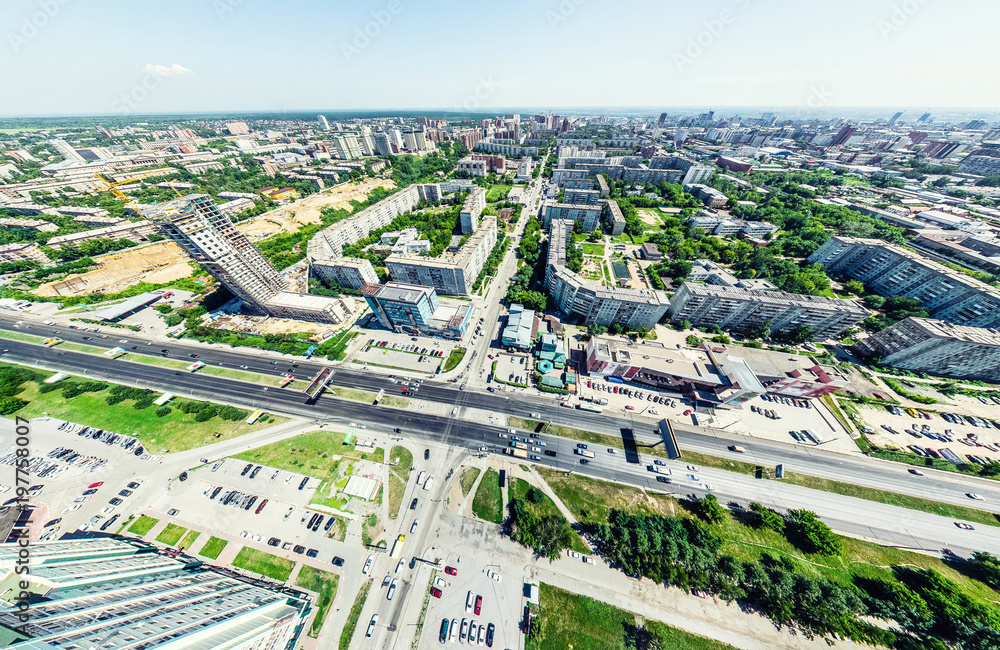 Aerial city view with crossroads and roads, houses, buildings, parks and parking lots, bridges. Helicopter drone shot. Wide Panoramic image.