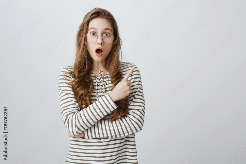 Have you seen shocking scene already. Stunned and surprised attractive female student in glasses pointing at upper right corner, dropping jaw from interest and amazement, being affected with news Have you seen shocking scene already. Stunned and surprised attractive female student in glasses pointing at upper right corner, dropping jaw from interest and amazement, being affected with news