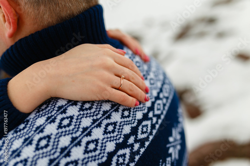 Boyfriend and girlfriend traveling lifestyle, tranquility and contemplation on a cold winter vacation. Winter nature. Young couple in winter warm sweaters and jeans hugging in the Park in winter. © korchemkin