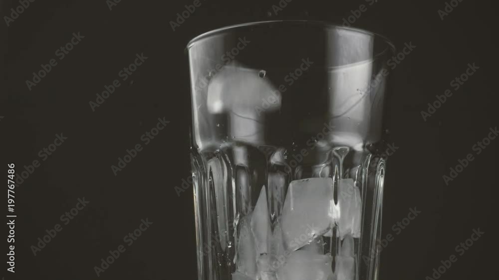 Slow motion. Pieces of ice fall into a glass Slow motion. Pieces of ice fall into a glass