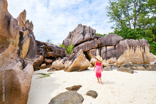 female tourist admires beautiful granite rocks on curieuse island, praslin, seychelles island photo