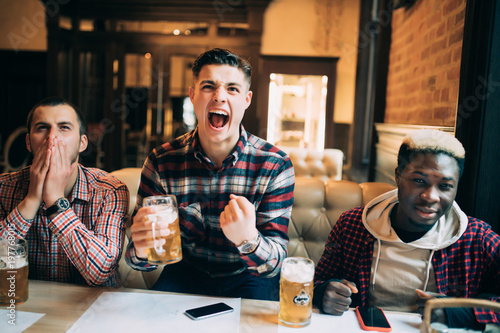 Quadro su tela Cheerful Multiracial friends grouphaving fun at the beer pub watching game on TV