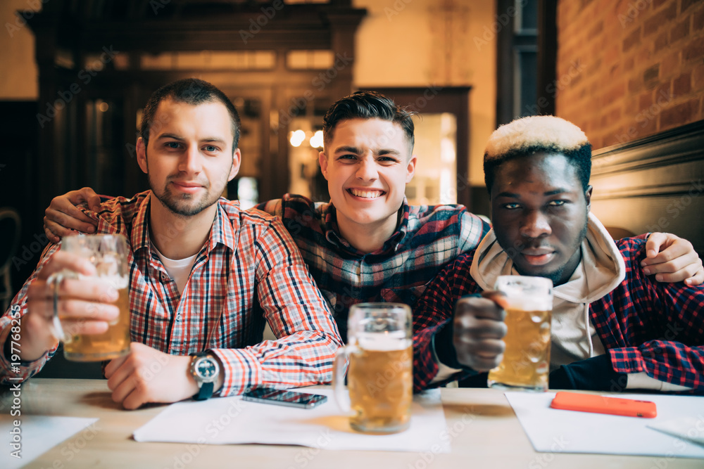 happy students male friends drinking beer at bar or pub
